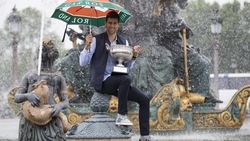 Roland Garros, Djokovic con ombrello a una mano e Coppa all'altra!