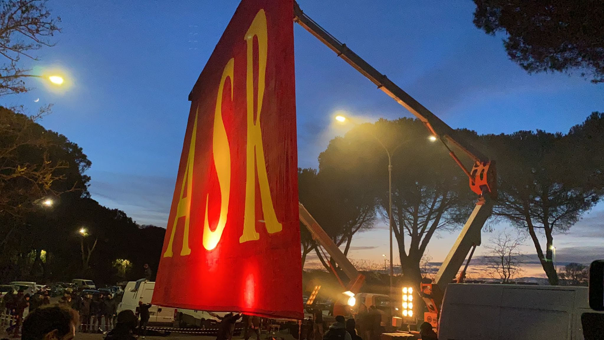 Tifosi della Roma davanti a Trigoria: uno striscione tirato su da una gru