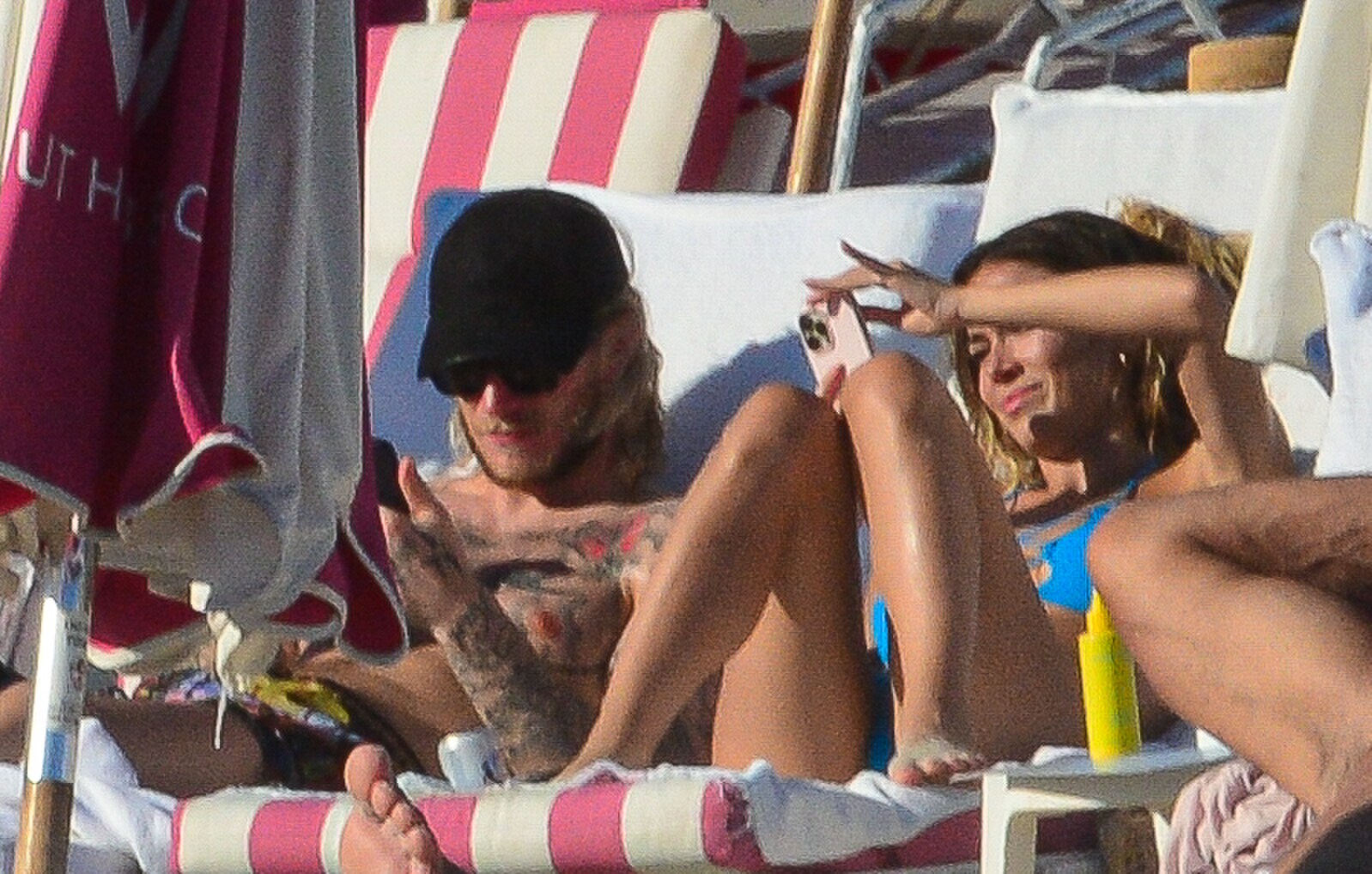 Дилетта Леотта расслабляется на диване, проверяя свой мобильный телефон, как и ее новый партнер.