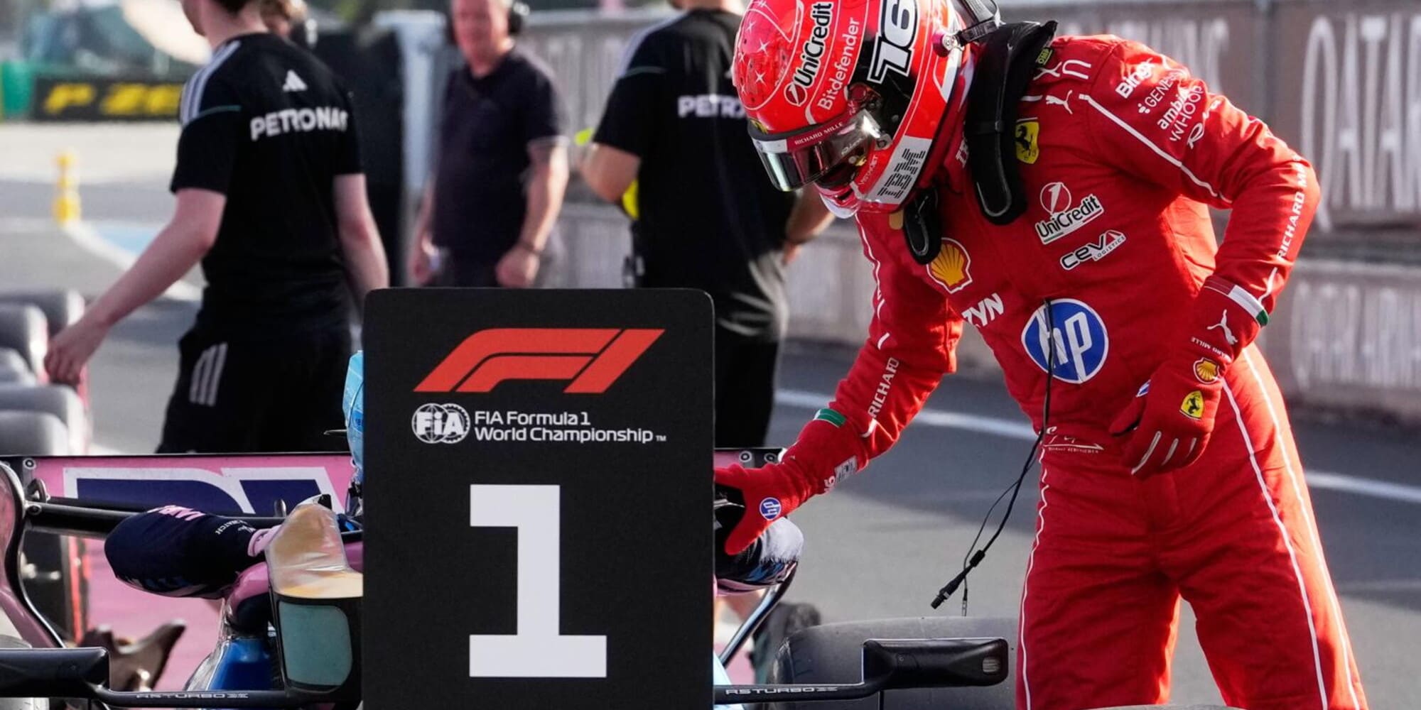 Un gruppo di persone si stringe la mano e si abbraccia dopo la vittoria di un pilota in Formula 1, condividendo l'emozione del momento