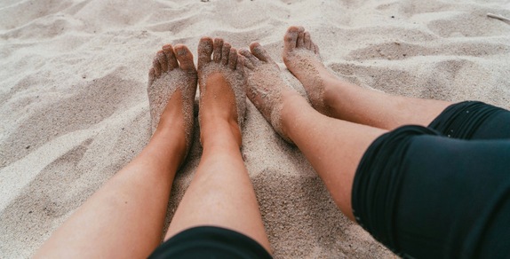 Né con l'acqua né con le mani: il trucco virale per togliere la sabbia dai piedi