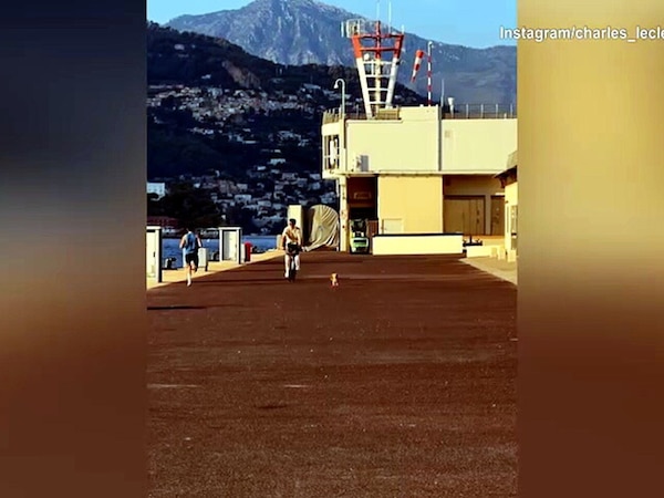 Leclerc in bici seguito dal cagnolino